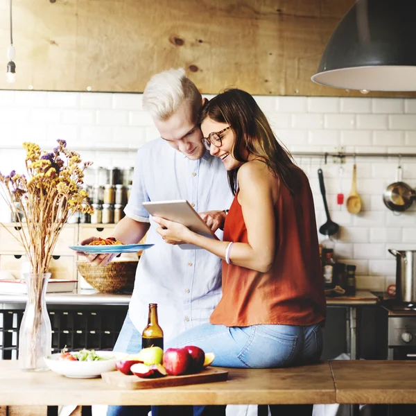 Casal na cozinha com dispositivo digital — Fotografia de Stock