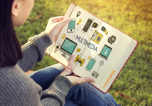 Woman reading book and multimedia — Stock Photo, Image