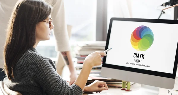 Frau zeigt auf Monitor mit Cmyk — Stockfoto