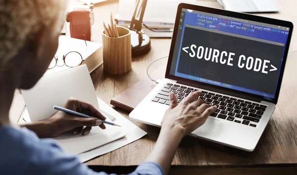 Vrouw die op laptop met source code werkt — Stockfoto
