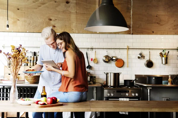 Couple en cuisine avec appareil numérique — Photo