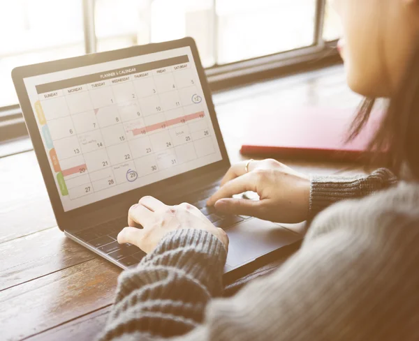 Vrouw typen op laptop met kalender — Stockfoto