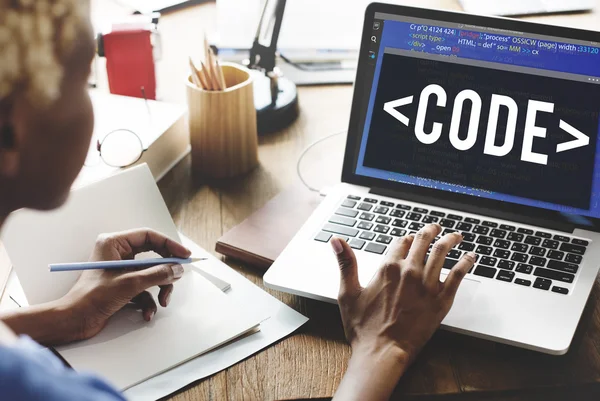 Woman working on laptop with code — Stock Photo, Image