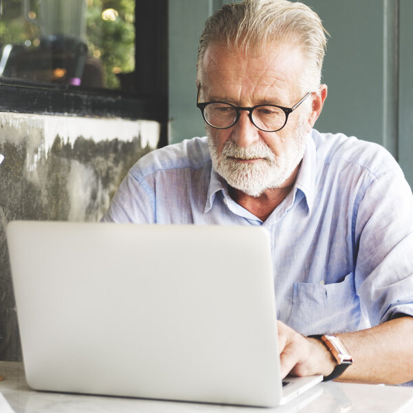 Зрелый мужчина с бородой с помощью цифрового устройства
