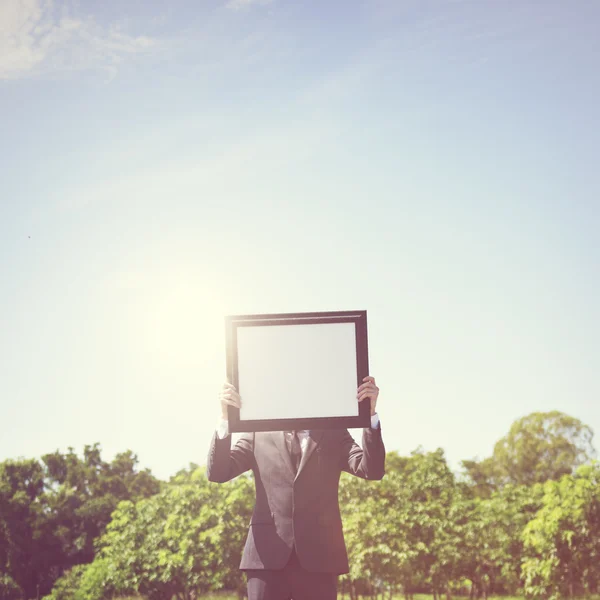 Podnikatel, stojící s rámečkem — Stock fotografie