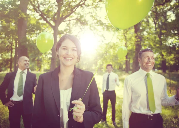 People outdoors holding green balloons — Stock Photo, Image