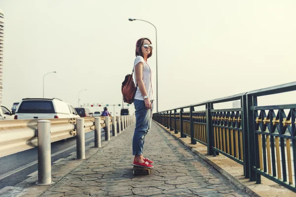 Femme avec skateboard et écouteurs — Photo