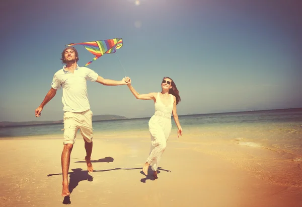 Couple jouant au cerf-volant sur la plage — Photo