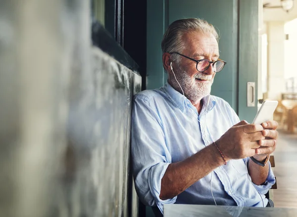 Älterer Mann mit Bart nutzt digitales Gerät — Stockfoto