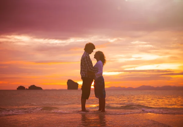 Koppel op strand tijdens zonsondergang — Stockfoto