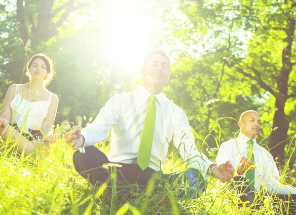 Business people meditating outdoors — Stock Photo, Image