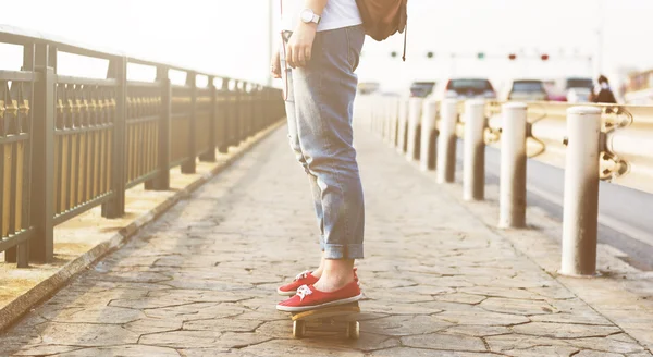 Mulher com skate e fones de ouvido — Fotografia de Stock