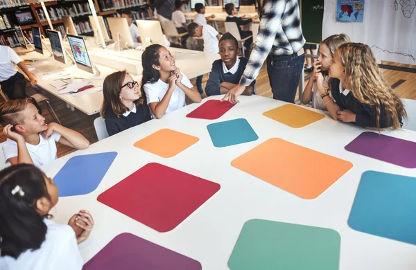 Grupo de crianças que estudam na biblioteca — Fotografia de Stock