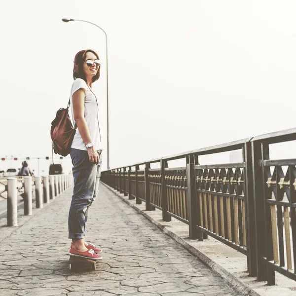 Femme avec skateboard et écouteurs — Photo