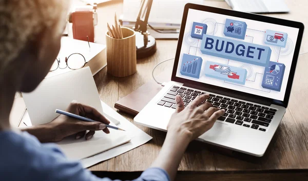 Woman working on laptop with budget — Stock Photo, Image
