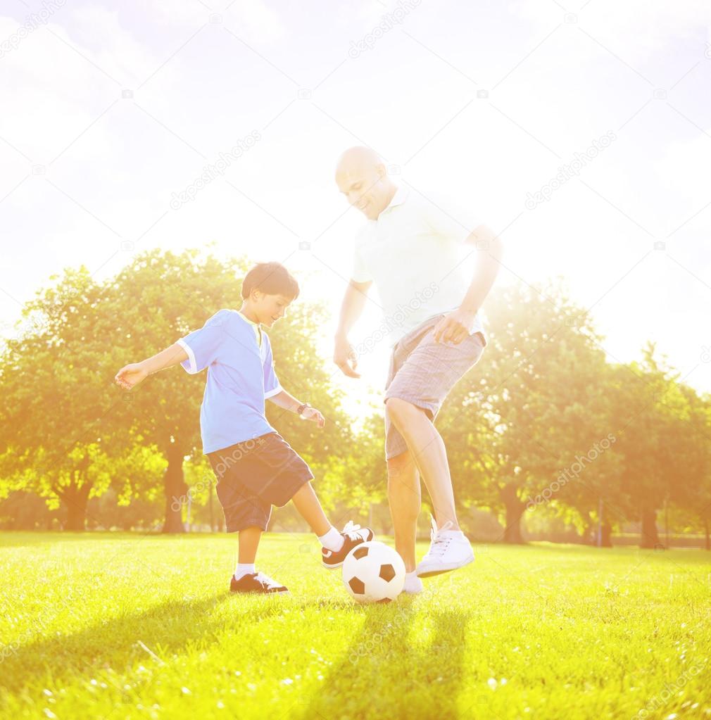 father playing football with little son