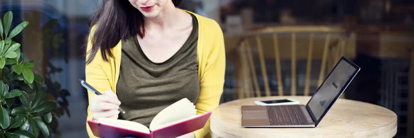 Портрет женщины с книгой и ноутбуком — стоковое фото