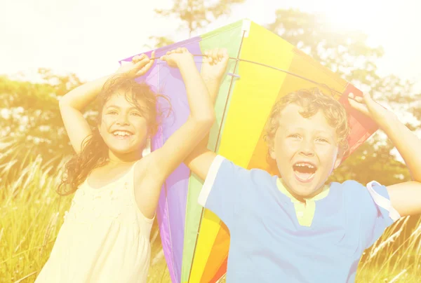 Vrolijke kinderen spelen met vlieger — Stockfoto