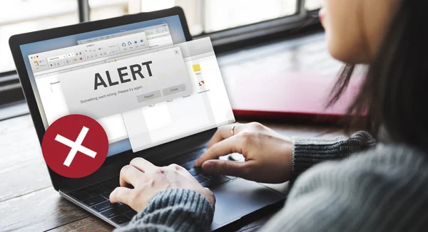 Kvinna att skriva på laptop med Alert — Stockfoto