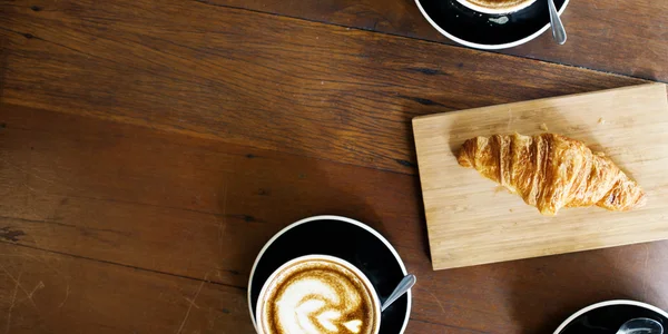 Kaffe och croissant på bordet — Stockfoto