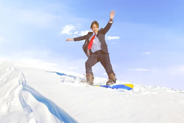 Businessman snowboarding on mountain — Stock Photo, Image