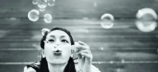 Азиатская женщина надувает пузыри — стоковое фото