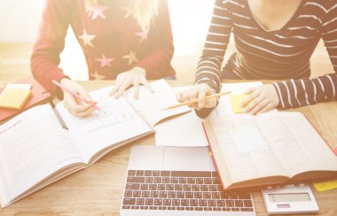 Kitap ve bilgisayar ile okuyan insanlar