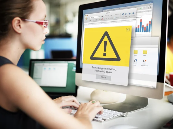 Businesswoman working on computer with error message — Stock Photo, Image
