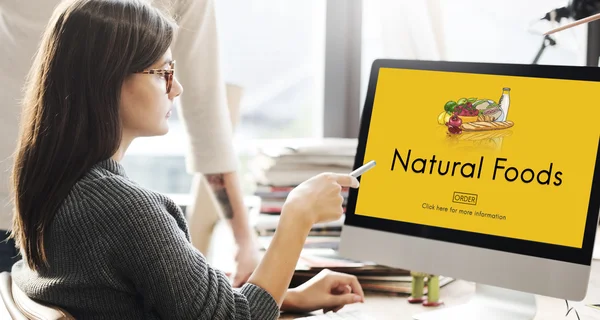 Kobieta pokazując na monitor z naturalnych produktów spożywczych — Zdjęcie stockowe