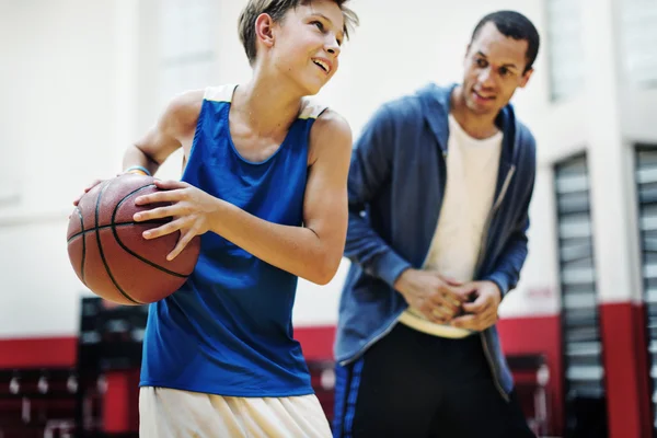 Sportsman undervisning pojke spela basket — Stockfoto