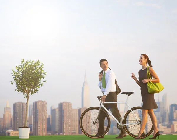 Business couple with bicycle — Stock Photo, Image