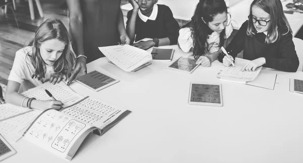 Group of children studying in library — ストック写真