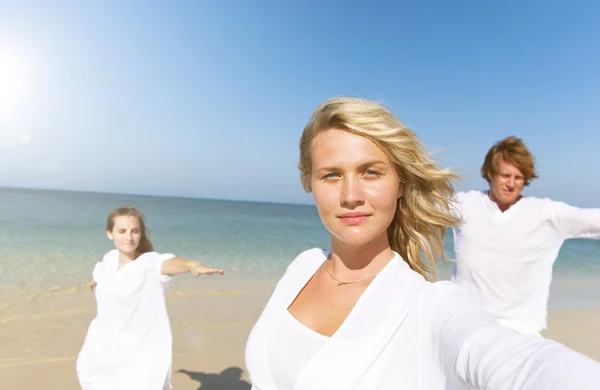 Människor som utför yoga på stranden — Stockfoto