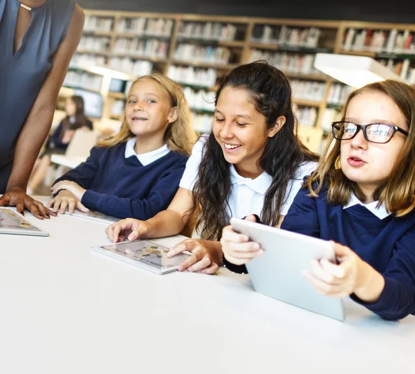 Grupa dzieci studiujących w bibliotece — Zdjęcie stockowe