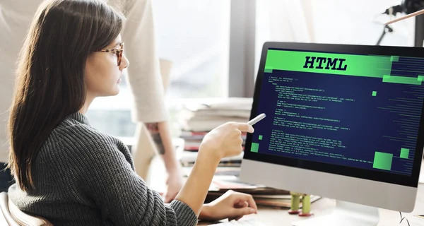 Frau zeigt auf Monitor mit HTML — Stockfoto