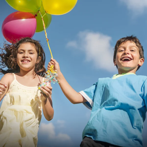 Дети играют с цветными воздушными шарами — стоковое фото