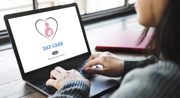 Woman typing on laptop with Day Care — Stock Photo, Image