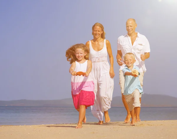 Familia feliz con niños en la playa — Foto de Stock