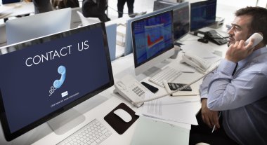 Bize ulaşın olan bilgisayarlarda çalışan iş adamı