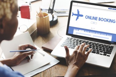 Online rezervasyon ile dizüstü bilgisayar üzerinde çalışan kadın