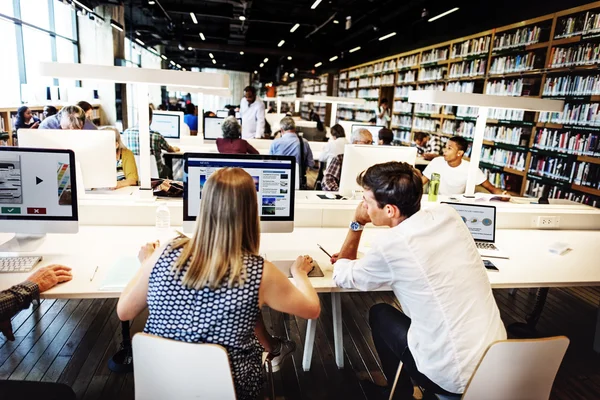 Estudiantes usando computadora en biblioteca — Foto de Stock