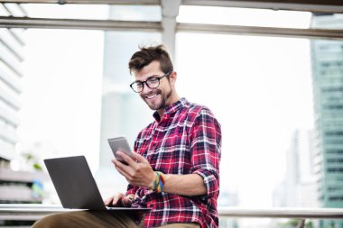 dizüstü bilgisayar ve smartphone genç adam