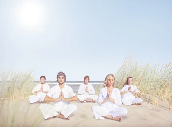 Mensen presterende yoga op het strand — Stockfoto