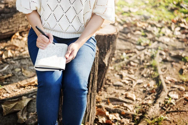 Vrouw schrijven in park — Stockfoto