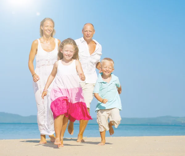 Rodzina działa na plaży — Zdjęcie stockowe