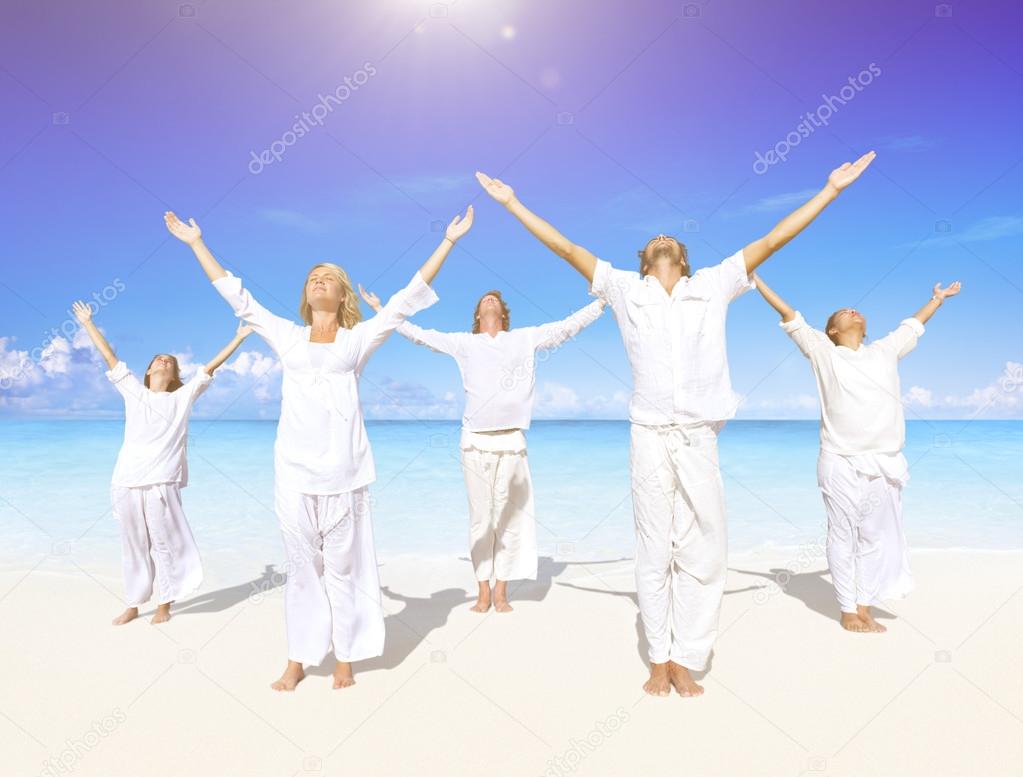 People performing yoga on beach