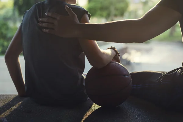 Sportman onderwijzen van jongen spelen basketbal — Stockfoto