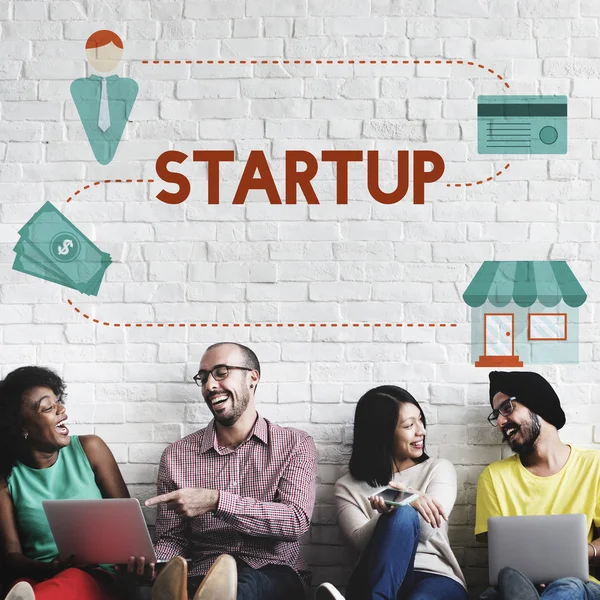 Diversity friends near wall with startup — Stock Photo, Image