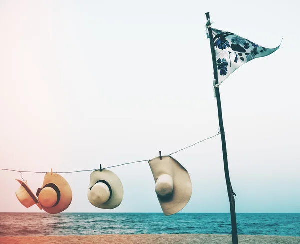 Bandiera e cappelli sulla spiaggia estiva — Foto Stock