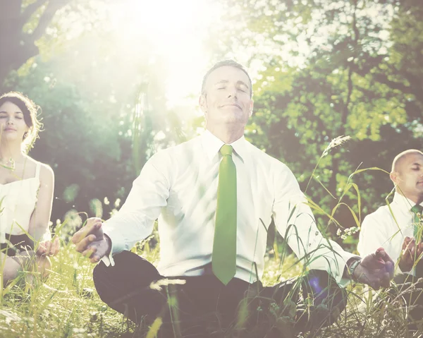 Business people meditating outdoors — Stockfoto